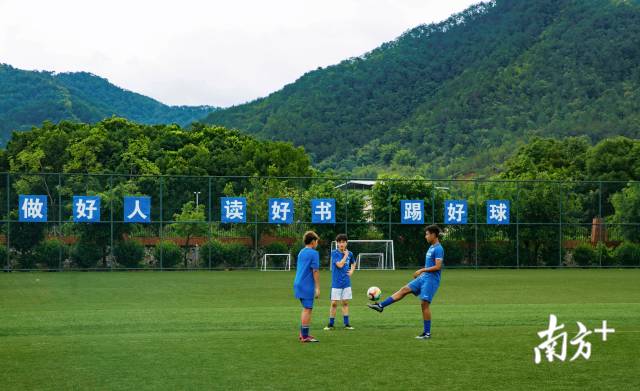 依木然和同样来自新疆的伙伴一起在学校球场踢球。