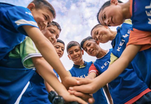 明德小学，一场足球练习赛开始前，队员们互相打气加油。