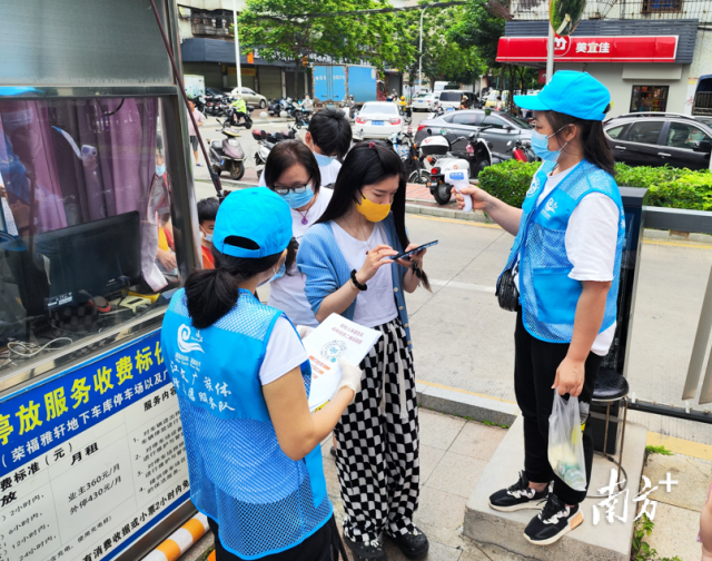 党员志愿者在街道协助测量体。