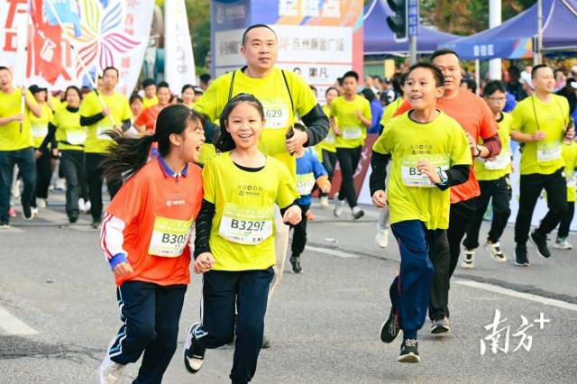 两名小朋友手牵手跑出起点。张晓欣 摄